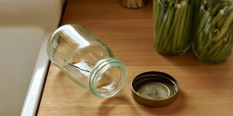 Cracked jar and buckled lid beside intact sealed jars