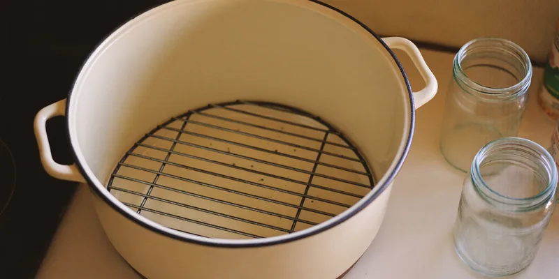 Round wire canning rack inside an open enamel pot