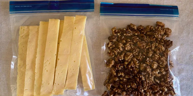 Zipper bags of cheese and walnuts on a linen cloth