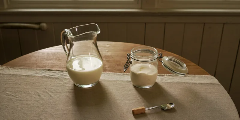 Pitcher of milk beside an open jar of milk powder