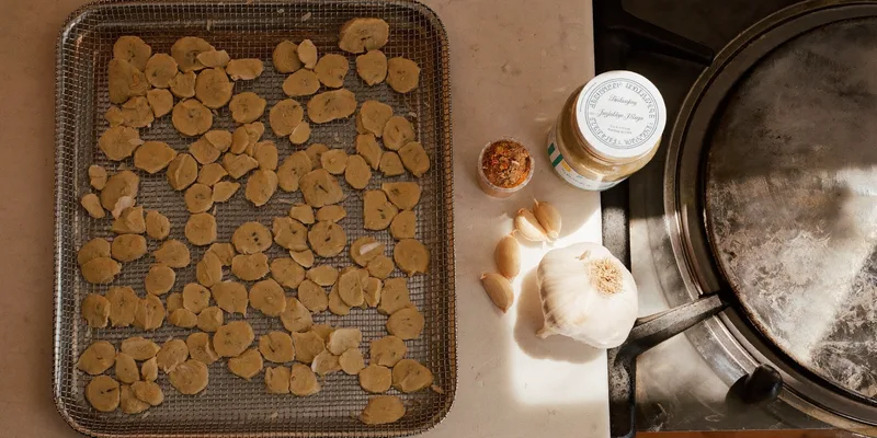 Garlic slices on a mesh tray with bulbs and powder
