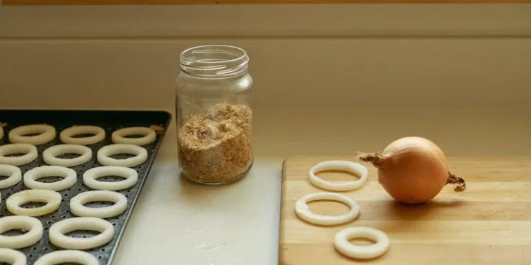 Onion rings on a tray beside a jar of dried flakes