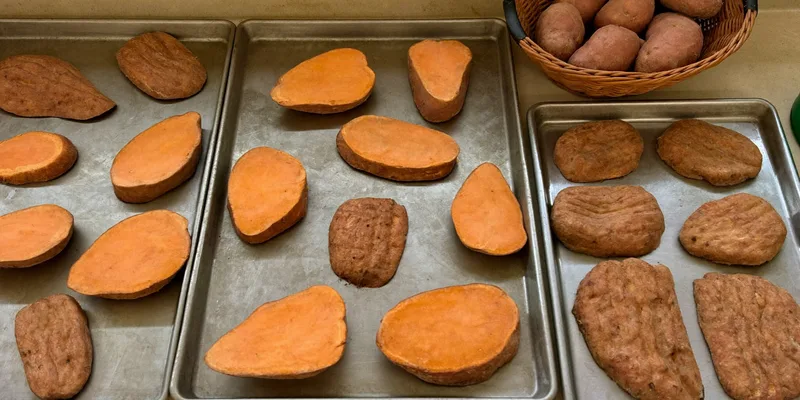 Sweet potato slices on trays with whole sweet potatoes