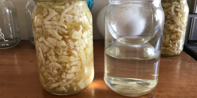 Jar with cabbage beside a jar of clear brine