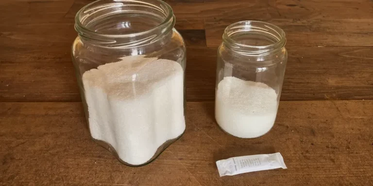 Jar of clumped hard sugar beside loose sugar and a sachet