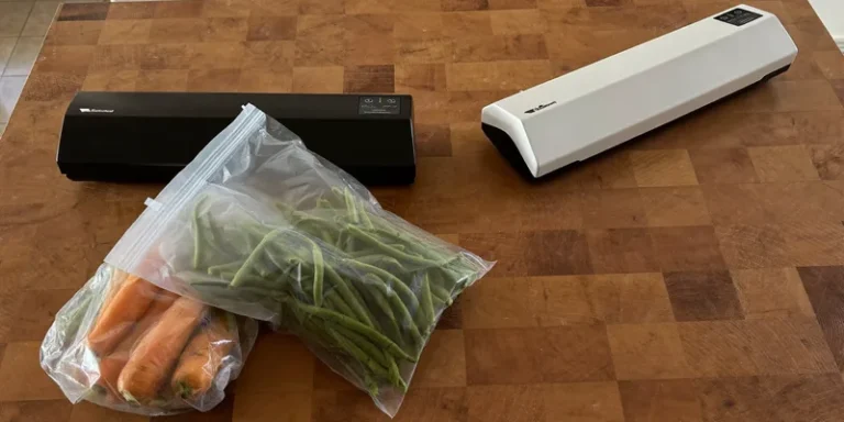 Two vacuum sealers side by side with a bag of carrots between them