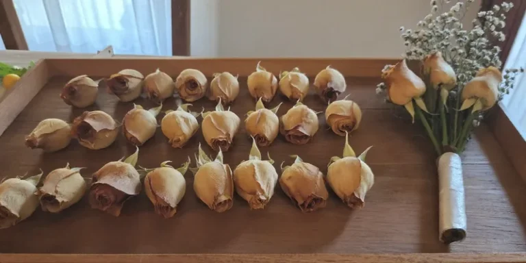 Freeze dried rose heads on a wooden tray with a bouquet