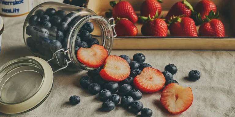 Freeze dried blueberries and strawberry slices spilling from a jar