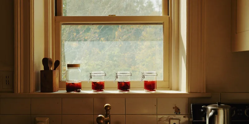 Small jelly jars glowing on a sunny windowsill