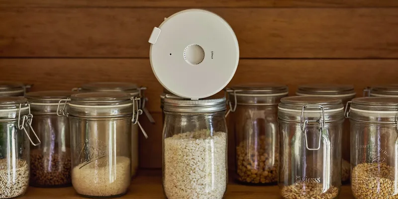 Round white vacuum sealing unit on top of a jar of rice