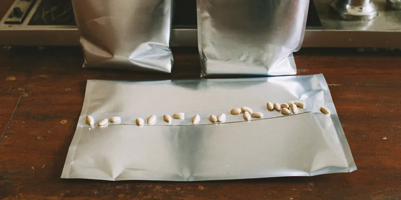 Flat silver mylar bags with a sealing bar and grains