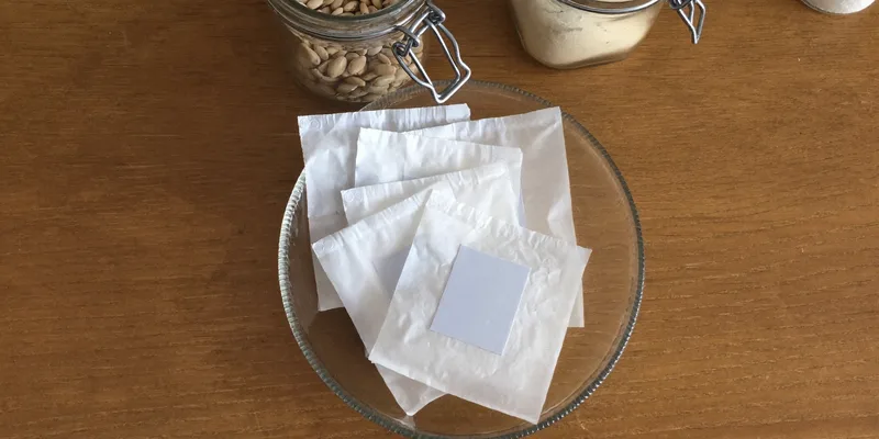Dish of blank white sachets beside jars of rice and beans
