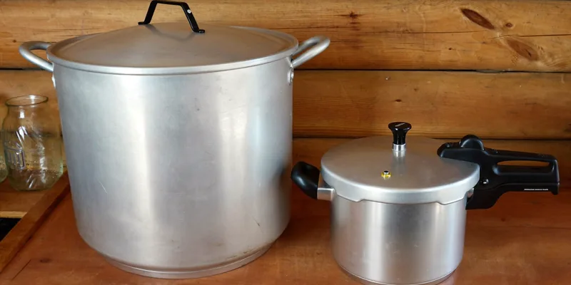 Tall pressure canner beside a small stovetop pressure cooker