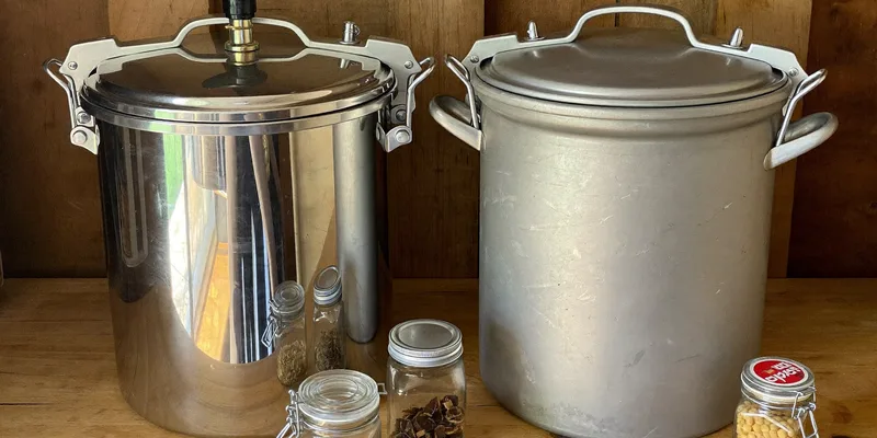 Two large pressure canners side by side with jars