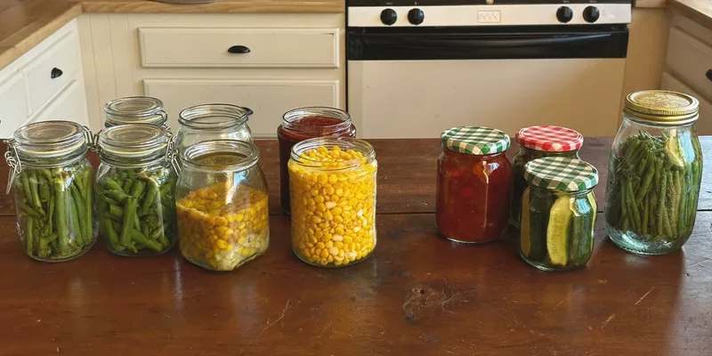 Jars of vegetables and stew grouped apart from jam and pickles